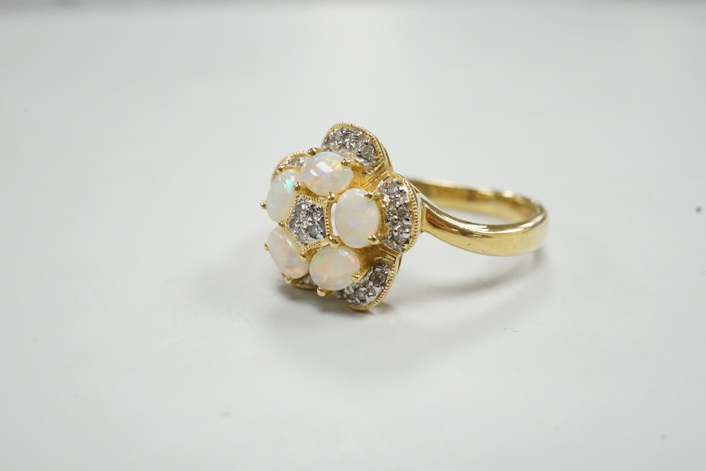 A modern 18k yellow metal, white opal and diamond chip set flower head cluster ring, size P, gross weight 4 grams.